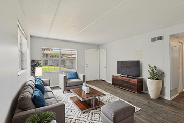 Eustis apartment for rent - A living room with a grey couch, a coffee table, and a television.