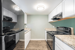 Tampa apartment for rent - a kitchen with white cabinets and black appliances at Bella Mar Apartments