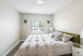 Orlando apartment for rent - A bedroom with a large bed and a window overlooking a street.
