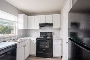 Orlando apartment for rent - A kitchen with black appliances and white cabinets.