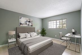 Tampa apartment for rent - A bedroom with a large bed, a desk, and a chair.