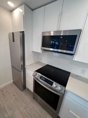 Vancouver apartment for rent - a kitchen with a stove a refrigerator and a microwave