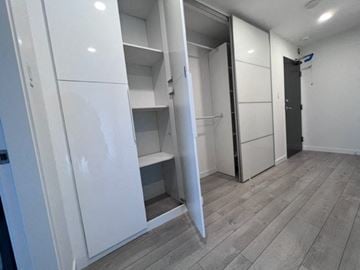 Vancouver apartment for rent - A white kitchen with a refrigerator and a door open.