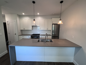 Vancouver apartment for rent - a kitchen with white cabinets and a gray counter top