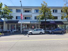Vancouver apartment for rent - a city street with a large white building in the background and two cars parked in front of