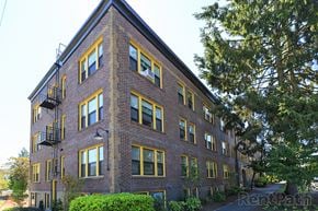 Seattle apartment for rent - a red brick apartment building with yellow and black windows
