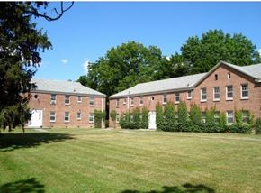 Ithaca apartment for rent - A large brick building with a green lawn in front.