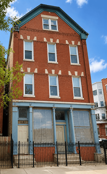 Chicago apartment for rent - A red brick building with a blue door and windows.