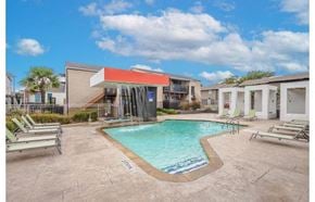 Dallas apartment for rent - a swimming pool with chairs and a building in the background at Cityscape, Dallas, TX