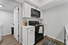 Dallas apartment for rent - a white kitchen with a black stove and a microwave at Lakeside Apartments, Dallas, TX