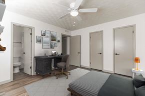 Dallas apartment for rent - a bedroom with a bed and a desk and a ceiling fan