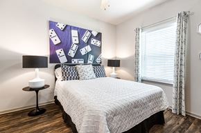 Covington apartment for rent - Furnished model bedroom with a window and wood-designed flooring at Reagan Crossing in Covington, LA