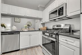 Owings Mills apartment for rent - a kitchen with white cabinets and stainless steel appliances