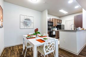 Covington apartment for rent - Dining area with table and four place settings open to the kitchen at Reagan Crossing in Covington, LA