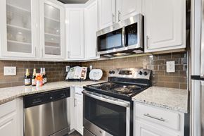 Pikesville apartment for rent - a kitchen with white cabinets and stainless steel appliances