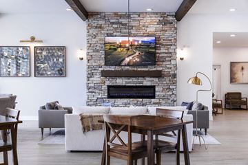 Rome apartment for rent - A modern living room with a stone fireplace and a television mounted above it.