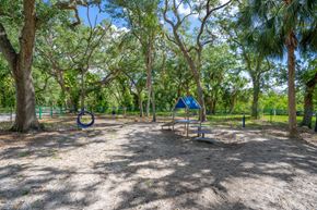 Tampa apartment for rent - A playground with a swing set and a blue ring in the middle of the sand.