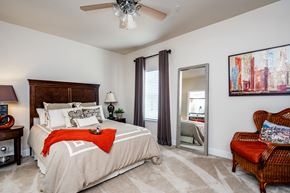 Macon apartment for rent - Furnished master bedroom with ceiling fan, carpet flooring, and window at Riverstone apartments for rent in Macon, GA