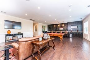 Macon apartment for rent - Clubhouse lounge with sofa and TV, pool table, and communal kitchen with bar counter at Riverstone apartments for rent in Macon, GA