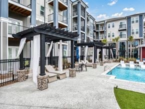 Ladson apartment for rent - a swimming pool is next to an apartment building