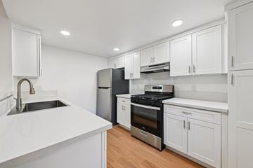 Ventura apartment for rent - A modern kitchen with white cabinets and stainless steel appliances.