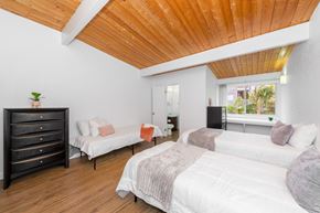 Goleta apartment for rent - A bedroom with a white bed and a wooden ceiling.
