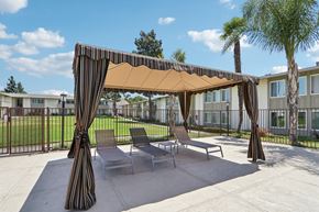 Camarillo apartment for rent - A patio with a striped canopy and chairs.