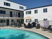 Camarillo apartment for rent - a resort style pool with chairs and umbrellas in front of two buildings