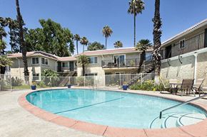 Camarillo apartment for rent - a swimming pool in front of a building with palm trees