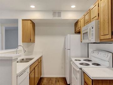 Las Vegas apartment for rent - a kitchen with white appliances and wooden cabinets