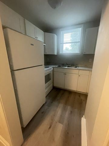 Charlotte apartment for rent - A white refrigerator is in a kitchen with wooden floors.