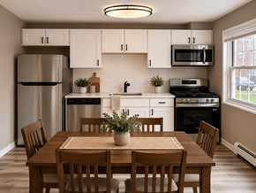 Madison apartment for rent - A kitchen with a table and chairs in the foreground and a refrigerator, microwave, oven, and sink in the background.