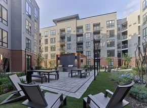 Bayonne apartment for rent - a courtyard with tables and benches in front of an apartment building