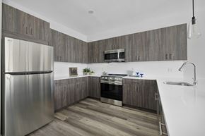 Clifton apartment for rent - A modern kitchen with a stainless steel refrigerator and wooden cabinets.