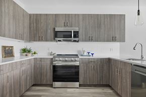 Clifton apartment for rent - A modern kitchen with a stove top oven and microwave above it.