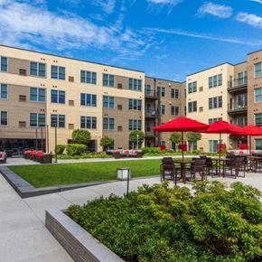 Englewood apartment for rent - a courtyard with tables and umbrellas in front of an apartment building