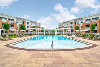 Resort style pool with white pergola and lounge seating