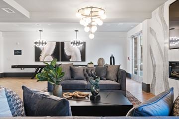 Allendale apartment for rent - A modern living room with a grey couch and a large painting on the wall.