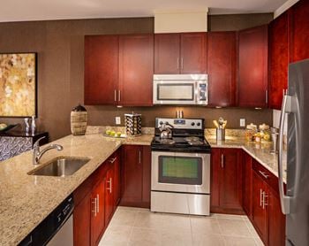 Kitchen with cherry wood cabinetry and granite counters