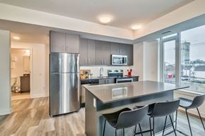 Ottawa apartment for rent - a kitchen with stainless steel appliances and a counter with three chairs