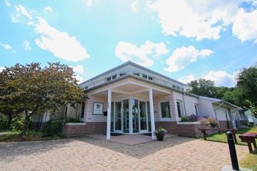 Blacksburg apartment for rent - the front of a white house with a brick sidewalk and a porch