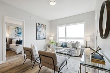 Kitchener apartment for rent - A living room with a white couch and a painting on the wall.