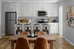 Kamloops apartment for rent - A modern kitchen with a wooden table and chairs.