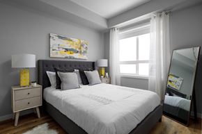West Kelowna apartment for rent - a bedroom with gray walls and a white bed