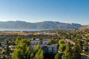 West Kelowna apartment for rent - a cityscape with a lake and mountains in the background