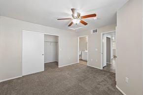 Las Vegas apartment for rent - A spacious room with a ceiling fan and carpeted floor.