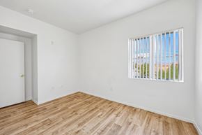Las Vegas apartment for rent - A room with a white door and a window with a view of a building and trees outside.