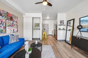 Las Vegas apartment for rent - A living room with a blue couch, a coffee table, and a ceiling fan.
