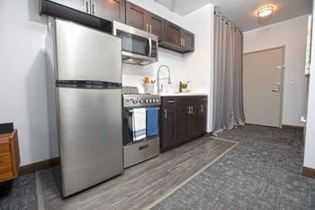 A kitchen with a stainless steel refrigerator and stove