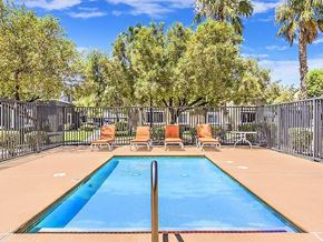 Las Vegas apartment for rent - a swimming pool with chairs and a fence at Silver Creek Apartments, Las Vegas, 89122